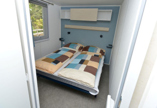 Interieur van glampingaccommodatie in Drau Camping Sachsenburg met tweepersoonsbed en raam.
