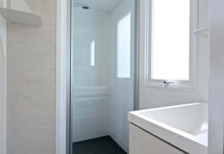 Salle de bain moderne et compacte avec douche dans un hébergement glamping au Drau Camping Sachsenburg, Carinthie.