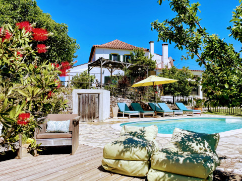Quinta Vida Verde - Glamping Portugal, alojamiento con piscina, tumbonas y jardines bajo un cielo azul.
