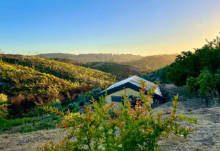Glamping-Unterkunft bei Sonnenuntergang auf dem malerischen Quinta Vida Verde in Portugal, umgeben von Natur.