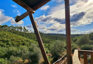 Uitzicht vanaf houten glamping accommodatie bij Quinta Vida Verde, Portugal, op groene heuvels en bos.