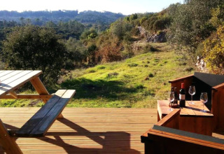 Glamping en Quinta Vida Verde, Portugal, con terraza, mesa de picnic, vino y vistas al bosque y montañas.