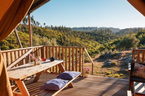 Glamping-indkvartering med træterrasse og udsigt over grønne bakker hos Quinta Vida Verde i Portugal.