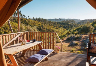 Glamping-indkvartering med træterrasse og udsigt over grønne bakker hos Quinta Vida Verde i Portugal.