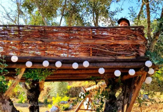 Boomhut bij Quinta Vida Verde - Glamping Portugal, sfeervol met lichtslinger en omgeven door natuur.