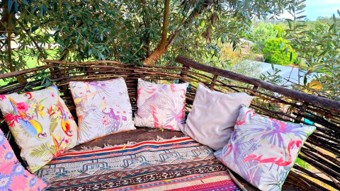 Udendørs glamping lounge hos Quinta Vida Verde i Portugal med farverige puder og træhegn i naturen.