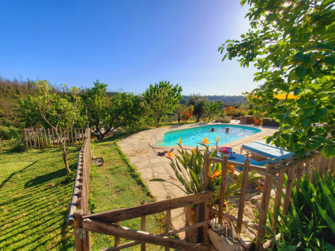 Poolbereich mit Liegestühlen und Gärten bei Quinta Vida Verde - Glamping Portugal, sonniger Tag.