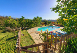 Sunny outdoor pool with loungers and lush greenery at Quinta Vida Verde - Glamping Portugal, relaxing scene.
