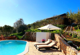 Piscina all'aperto con lettini e ombrellone a Quinta Vida Verde - Glamping Portugal in mezzo al verde.