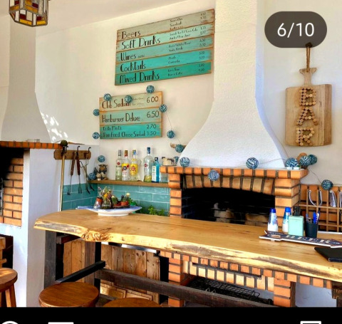 Gemütliche Bar bei Quinta Vida Verde - Glamping Portugal mit Holztresen, Spirituosen und Tafeln an der Wand.