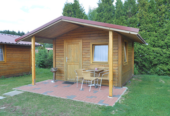 Blokhut met overdekt terras, barbecue en tuinset op Camping 'Am Leuchtturm' in Nedersaksen, Duitsland.