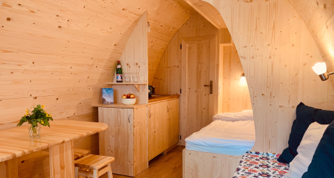 Indendørs udsigt over en hyggelig, moderne camping pod på Camping Blauer See Garbsen, lavet af lyst træ.