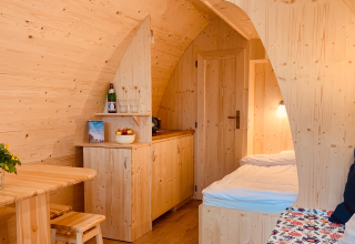 Interno accogliente di una pod di glamping in legno chiaro al Camping Blauer See Garbsen, Bassa Sassonia.