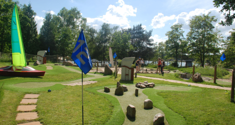 Minigolfplatz mit grüner Landschaft bei Camping Blauer See Garbsen – Pods Niedersachsen an einem sonnigen Tag.