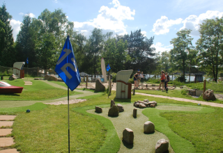 Campo de mini golf y zona verde en Camping Blauer See Garbsen - Pods Nedersaksen disfrutando de un día soleado.