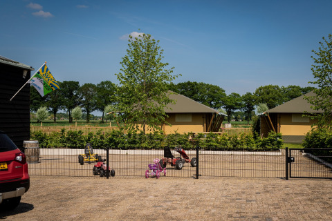 Glamping De Rode Vos con tende glamping a Noord-Brabant e veicoli giocattolo fuori dalle tende.