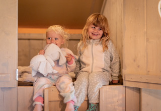 Dos niños pequeños en pijama disfrutan de su estancia en el alojamiento Glamping De Rode Vos en Noord-Brabant.