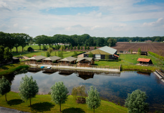 Vista aerea di Glamping De Rode Vos con tende di lusso sull’acqua e natura rigogliosa a Noord-Brabant.