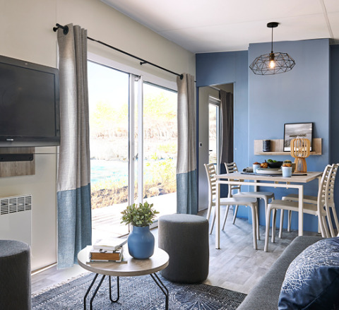 Moderne glampinghytte på Camping Les Charmes - Cottages Dordogne med hyggelig stue og spiseplads.