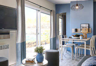 Modernes Glamping-Cottage bei Camping Les Charmes - Cottages Dordogne mit hellem Wohn- und Essbereich.