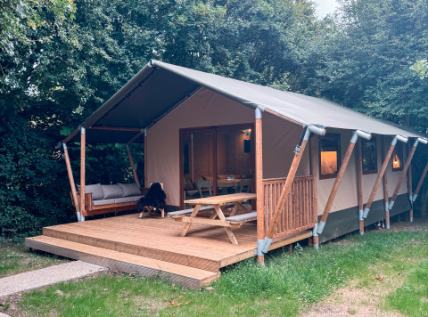 Moderne glampingtelt hos Urban Gardens Ieper i West-Vlaanderen med træterrasse og udendørs bænk.