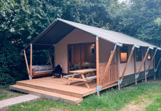 Glampingtent bij Urban Gardens Ieper in West-Vlaanderen met houten terras en ruime picknicktafel.