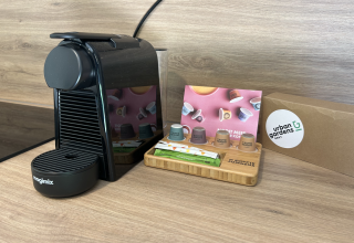 Schwarze Kaffeemaschine und Kaffeekapseln auf Tablett bei Urban Gardens Ieper Glampingtenten West-Vlaanderen.