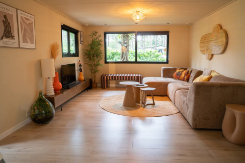 Salon chaleureux avec déco moderne au Camping Twente - Chalet Overijssel en hébergement glamping en forêt.