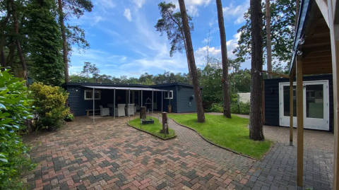 Außenansicht der Glamping-Unterkunft Camping Twente - Chalet Overijssel, umgeben von Bäumen und Natur.