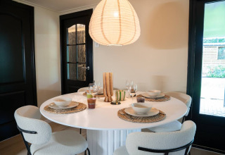 Zona pranzo moderna al glamping Camping Twente - Chalet Overijssel, tavola apparecchiata per quattro persone.