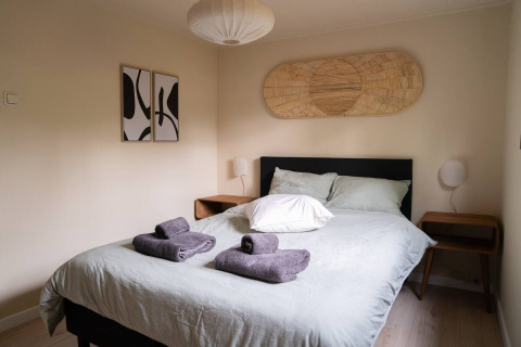 Modernes Schlafzimmer mit Doppelbett, Handtüchern und Dekor in Chalet Overijssel auf Camping Twente.