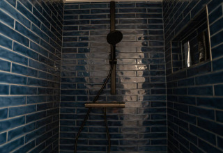 Ducha moderna con azulejos azul oscuro en alojamiento glamping de Camping Twente - Chalet Overijssel.