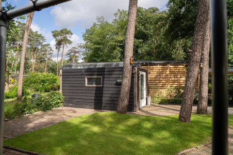 Moderne glamping accommodatie bij Camping Twente - Chalet Overijssel, omgeven door groene bomen.