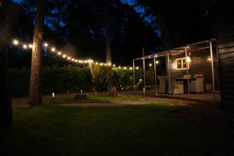Ambiance nocturne en extérieur avec guirlande lumineuse au Camping Twente - Chalet Overijssel, glamping.
