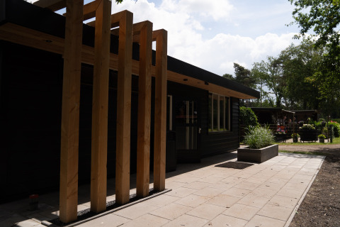 Modern glamping accommodation Camping Twente - Chalet Overijssel with wooden structure and outdoor area.