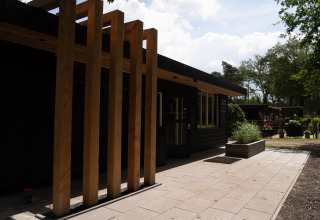 Moderne glampingaccommodatie Camping Twente - Chalet Overijssel met houten structuur en buitenruimte.