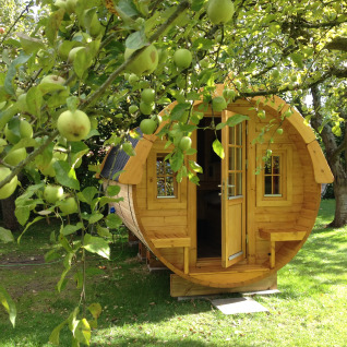 Alloggio glamping in botte di vino a Minicamping De Bokkepsprong, tra meli a Zeeland nei Paesi Bassi.