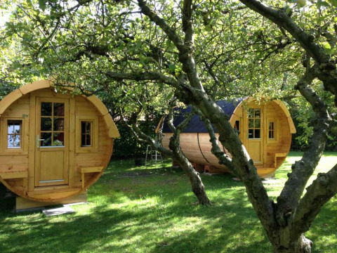 Dos cabañas de madera en forma de barril en Minicamping De Bokkepsprong, perfectas para glamping en Zeeland.