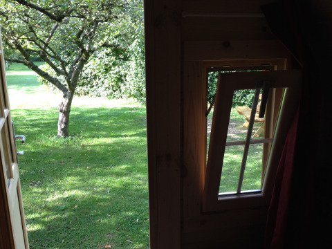 Uitzicht vanuit glamping accommodatie bij Minicamping De Bokkepsprong - Wijnvaten in Zeeland met geopend raam.