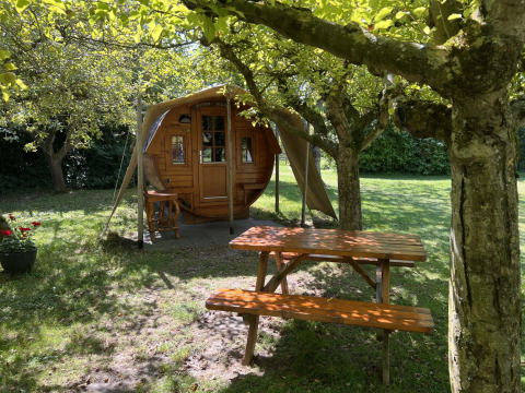 Alojamiento de glamping en Minicamping De Bokkepsprong en Zeeland, rodeado de árboles y mesa de picnic.