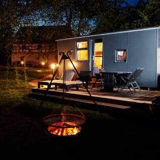 Udendørs natscene af glamping ved Handwerkerhof Fränkische Schweiz Zigeunerwagen med bål og terrasse.