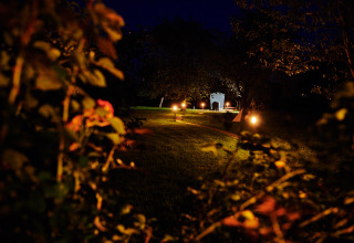 A night-lit path leads to a glamping wagon at Handwerkerhof Fränkische Schweiz in Bavaria, Germany.