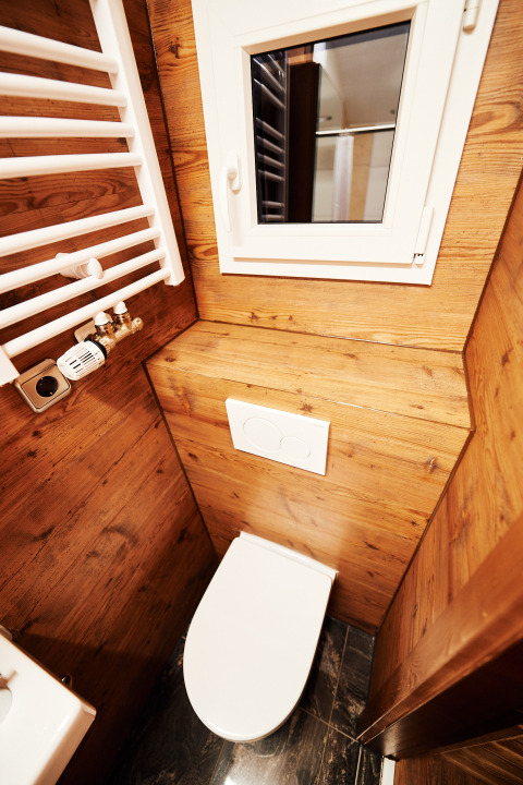 Bagno moderno con pannelli in legno, finestra e radiatore presso Handwerkerhof Fränkische Schweiz Zigeunerwagen.