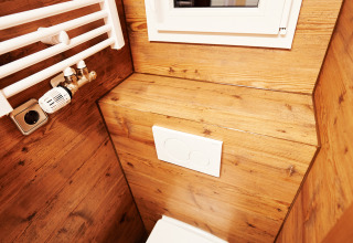 Modernes Badezimmer mit Holzwänden, Fenster und Toilette im Handwerkerhof Fränkische Schweiz Zigeunerwagen.