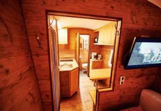 Interieur van een knusse glampingaccommodatie bij Handwerkerhof Fränkische Schweiz Zigeunerwagen met houten afwerking.