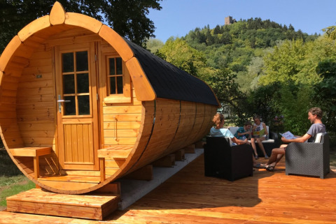 Alojamiento glamping en barril de vino de Camping Alf, Rheinland-Pfalz, personas relajándose afuera.