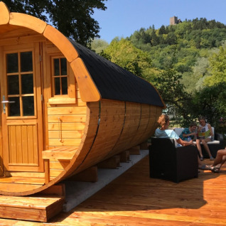 Glamping wijnvat bij Camping Alf in Rijnland-Palts, mensen genieten buiten van het terras.