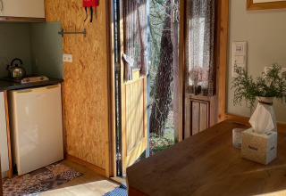 Intérieur de Lima Escape glamping au Portugal avec porte ouverte sur la nature et lumière du soleil.