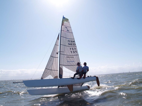 Zeilers genieten van het varen op een katamaran op het water bij Marina Parcs Almere in Flevoland.