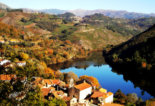 Vista panoramica su Lima Escape - Boomlodges e tende Glamping in Portogallo, accanto a un lago di montagna.